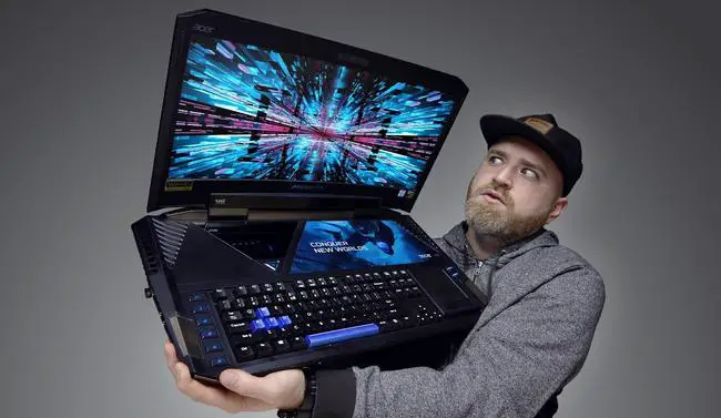 Man holding a big and heavy gaming laptop.